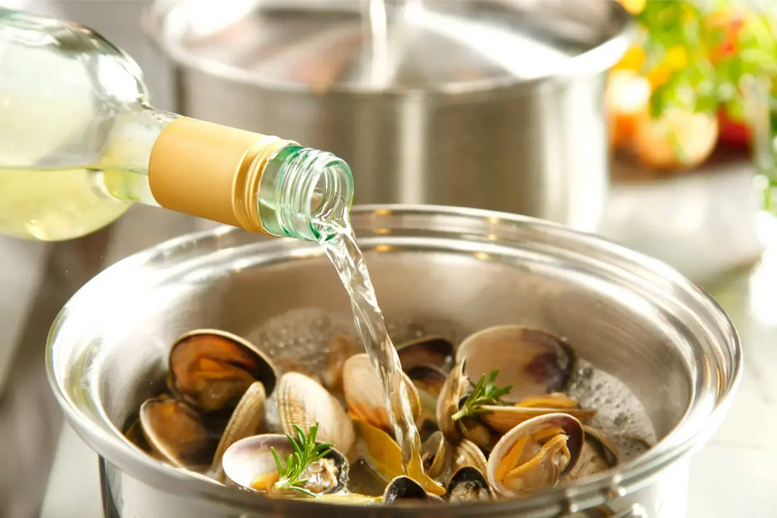 Glass and bottle of dry white wine on a kitchen table, perfect for cooking seafood, pasta, and sauces
