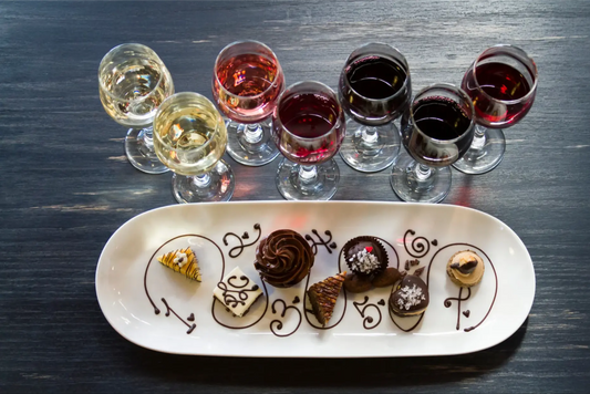 Selection of dessert wines paired with gourmet chocolates on a white platter