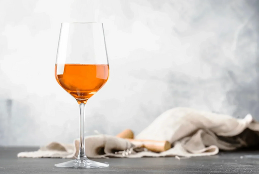 Glass of orange wine on table – featured image for guide explaining what orange wine is