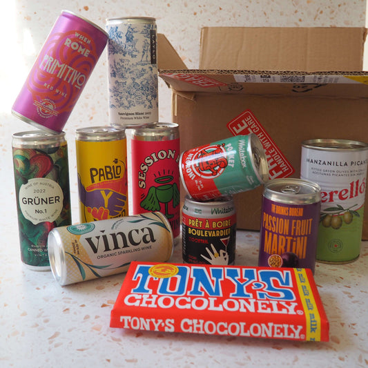 A gift including a selection of cans of wine, canned cocktails, olives and chocolate.