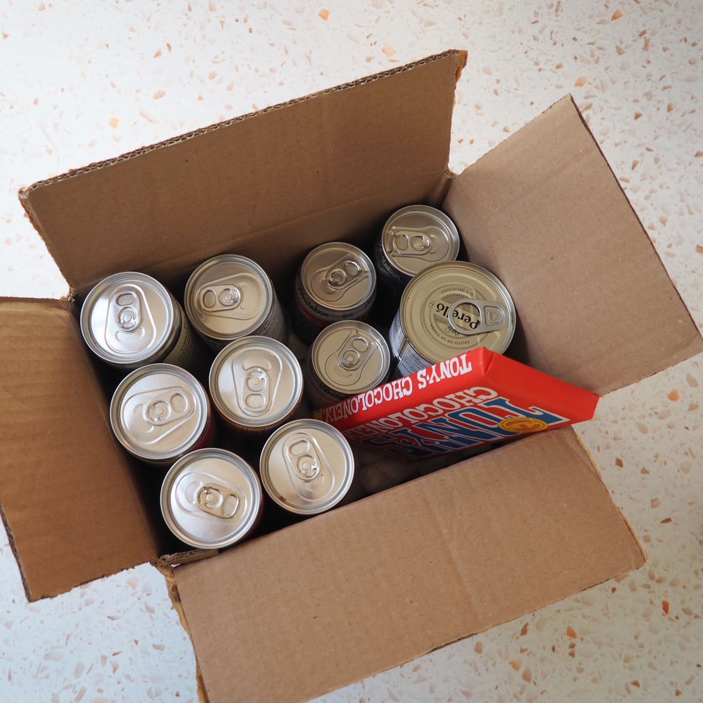 A gift including a selection of cans of wine, canned cocktails, olives and chocolate.